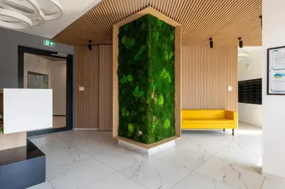 a green wall in a lobby with a yellow bench at Cracow Novum Apartment #533 by BookingHost in Kraków