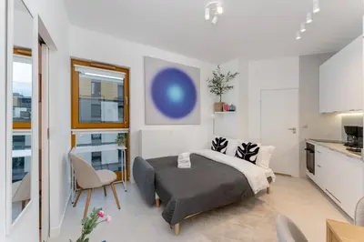 a bedroom with a large bed and a kitchen at Cracow Novum Apartment #533 by BookingHost in Kraków