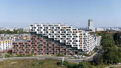an apartment building with a pyramid facade in a city at Cracow Novum Apartment #533 by BookingHost in Kraków