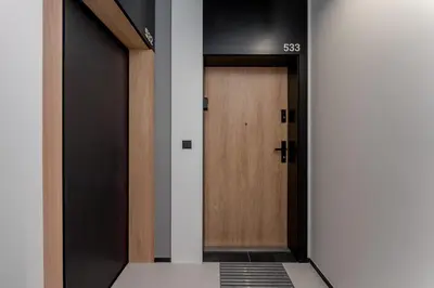 a corridor with a wooden door in a building at Cracow Novum Apartment #533 by BookingHost in Kraków