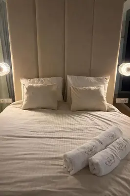 a white bed with two towels on top of it at Anielski Apartament z jacuzzi i sauną NOWY 2 sypialnie Relaks & SPA in Kraków