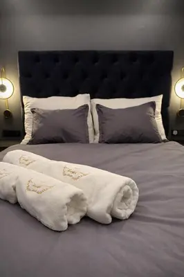 a bed with two white towels on top of it at Anielski Apartament z jacuzzi i sauną NOWY 2 sypialnie Relaks & SPA in Kraków