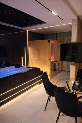 a living room with a tv and a table and chairs at Anielski Apartament z jacuzzi i sauną NOWY 2 sypialnie Relaks & SPA in Kraków