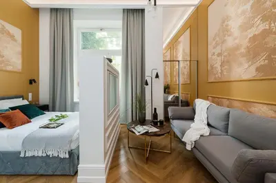 a bedroom and a living room with a bed and a couch at Gentle Glow Suite by Tyzenhauz in Kraków