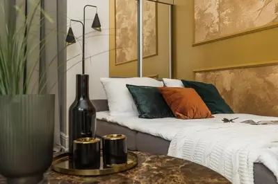 a living room with a couch and a table with a vase at Gentle Glow Suite by Tyzenhauz in Kraków