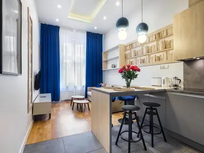 a kitchen with blue curtains and a kitchen island with stools at Gentle Glow Suite by Tyzenhauz in Kraków
