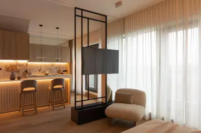a living room with a chair and a kitchen at Sunset Balcony City Center Free Parking in Kraków