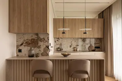 a kitchen with wooden cabinets and a counter with chairs at Sunset Balcony City Center Free Parking in Kraków