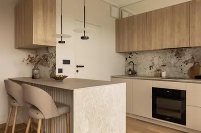 a kitchen with wooden cabinets and a counter with bar stools at Sunset Balcony City Center Free Parking in Kraków