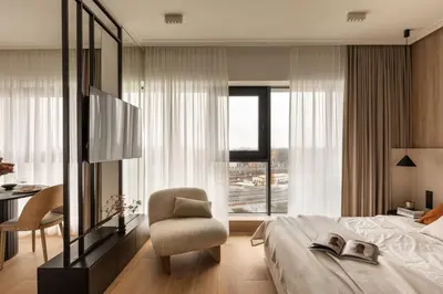 a bedroom with a bed and a chair and a window at Panorama suite City Center Main Station in Kraków