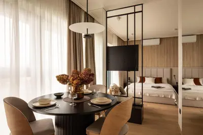 a room with a table and chairs and a bed at Panorama suite City Center Main Station in Kraków