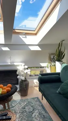 a living room with a green couch and a skylight at The perfect cozy Oasis in Kraków