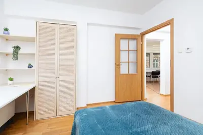 a bedroom with a bed and a wooden door at Apartment Warszauera 3 in Kraków
