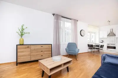 a living room with a blue couch and a table at Apartment Warszauera 3 in Kraków