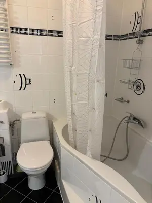 a bathroom with a toilet and a shower curtain at Apartment Warszauera 3 in Kraków