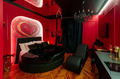 a bedroom with red walls and a bed in a room at Love Krak-Off - Studio BDSM Dream Theater in Kraków