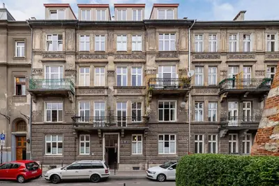 an old building with cars parked in front of it at Paulińska 30 Kraków Spacious Apartment Kazimierz in Kraków