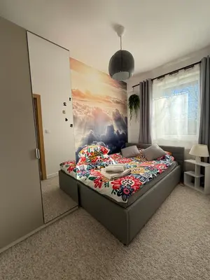 a bedroom with a bed with a painting on the wall at Wiślane Pianissimo apartament in Kraków