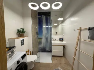 a bathroom with a shower and a toilet and a sink at Wiślane Pianissimo apartament in Kraków