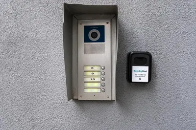 an electronic device attached to a wall with a cell phone at Cracow Vistula Harmony Apartment by BookingHost in Kraków
