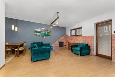 a living room with two green chairs and a table at Cracow Vistula Harmony Apartment by BookingHost in Kraków