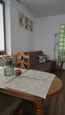 a living room with a couch and a table with a lamp at Park & Arena Apartament Kraków in Kraków