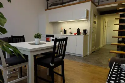 a kitchen with a table and chairs in a room at Apartament Elementos in Kraków
