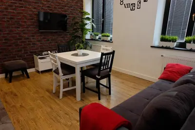 a living room with a table and a couch at Apartament Elementos in Kraków