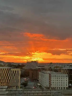 a view of a city with a sunset in the background at Skyline Suite Cracow - Walk to City Center & Main Train Station in Kraków