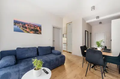 a living room with a blue couch and a table at Krakowiak Apartment 89 in Kraków