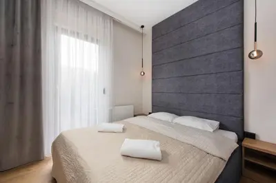 a bedroom with a large bed with two towels on it at Krakowiak Apartment 89 in Kraków