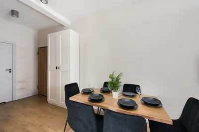 a dining room with a wooden table and chairs at Krakowiak Apartment 89 in Kraków