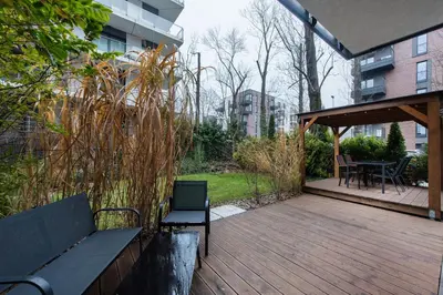 a wooden deck with a bench and a table and chairs at Krakowiak Apartment 89 in Kraków