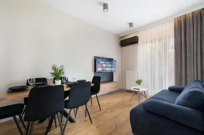 a living room with a table and a blue couch at Krakowiak Apartment 89 in Kraków