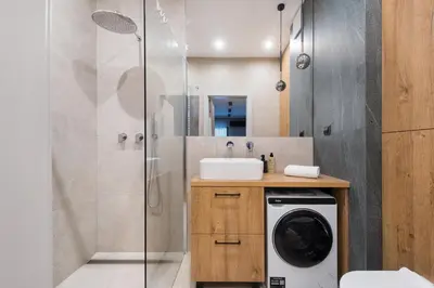 a bathroom with a sink and a washing machine at Krakowiak Apartment 89 in Kraków