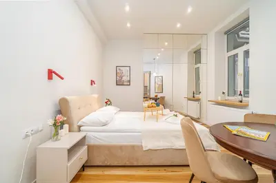 a bedroom with a bed and a table and a dining room at Design Apartment Kazimierz, Old Town Area in Kraków