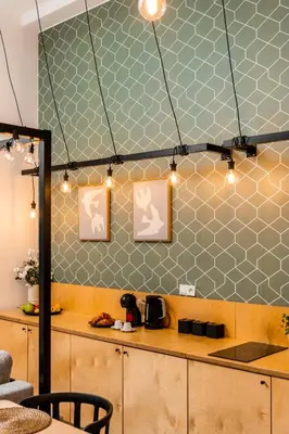 a kitchen with a counter with a table and lights at Old Town Loft Designed with Love in Kraków