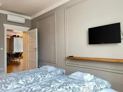 a bedroom with two beds and a flat screen tv at Premium Apartment for 6 guests city center with 2 bedrooms and living room in Kraków