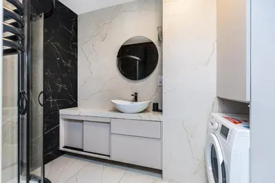 a bathroom with a sink and a washing machine at Riva Cracovia in Kraków