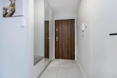 a hallway with a wooden door and a phone at Riva Cracovia in Kraków