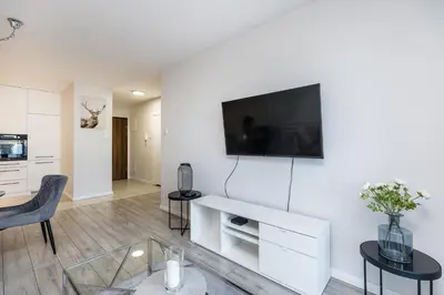 a living room with a tv on a white wall at Riva Cracovia in Kraków