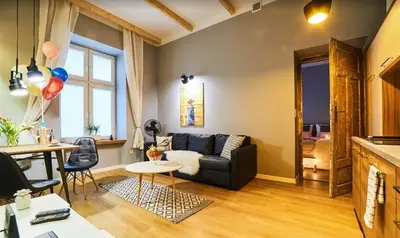 a kitchen with a table and chairs and a red couch at Krowoderska Comfort Apartments - by Upstairs in Kraków
