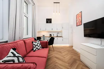a bedroom with a bed with pink and white pillows at Krowoderska Comfort Apartments - by Upstairs in Kraków