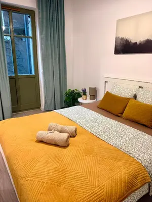 a bedroom with a large bed with two towels on it at Green Rest Apartment Cracow in Kraków