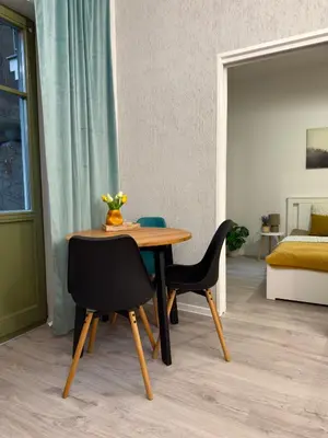 a dining table and two chairs in a room at Green Rest Apartment Cracow in Kraków
