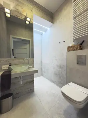 a bathroom with a white toilet and a sink at Green Rest Apartment Cracow in Kraków