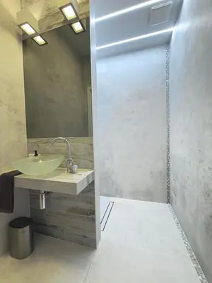 a bathroom with a shower with a sink and a mirror at Green Rest Apartment Cracow in Kraków