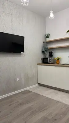 a kitchen with a flat screen tv on a wall at Green Rest Apartment Cracow in Kraków