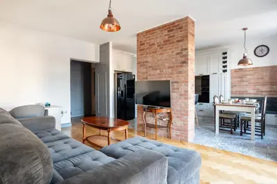 a living room with a couch and a brick fireplace at Wroblewskiego No 4 Residence in Kraków