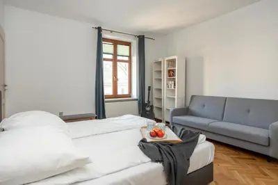 a living room with a bed and a couch at Wroblewskiego No 4 Residence in Kraków